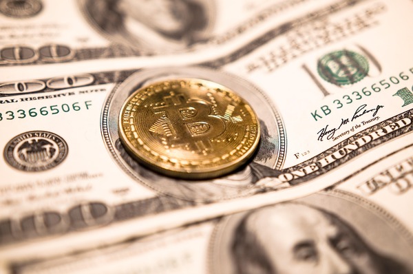 Silver Litecoin-style coin resting on a cryptocurrency price chart
