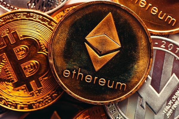 Bitcoin coin next to a cryptocurrency exchange chart